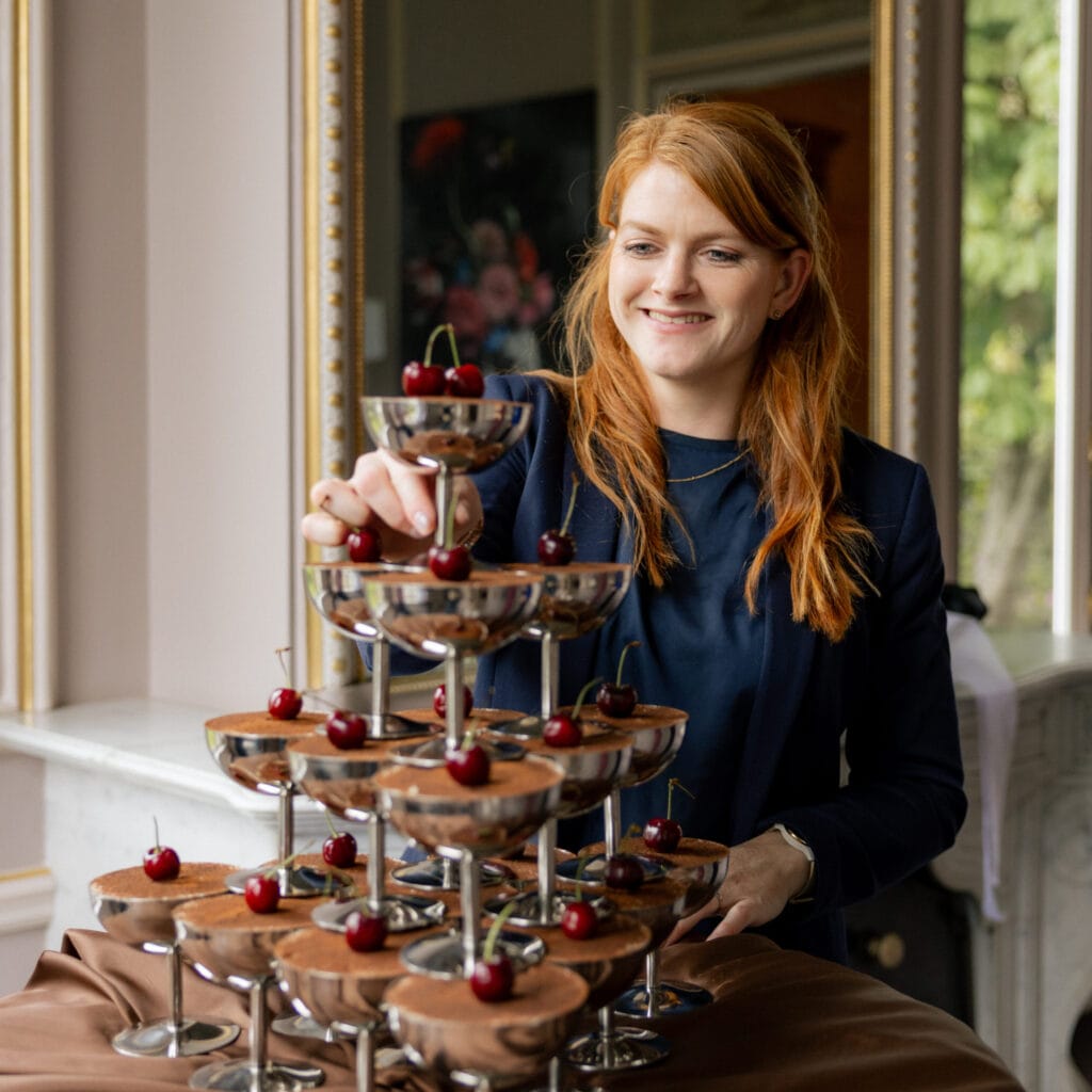 Ingrid van de Coevering legt als ceremoniemeester de laatste hand aan een champagnetoren met dessertcoupes
